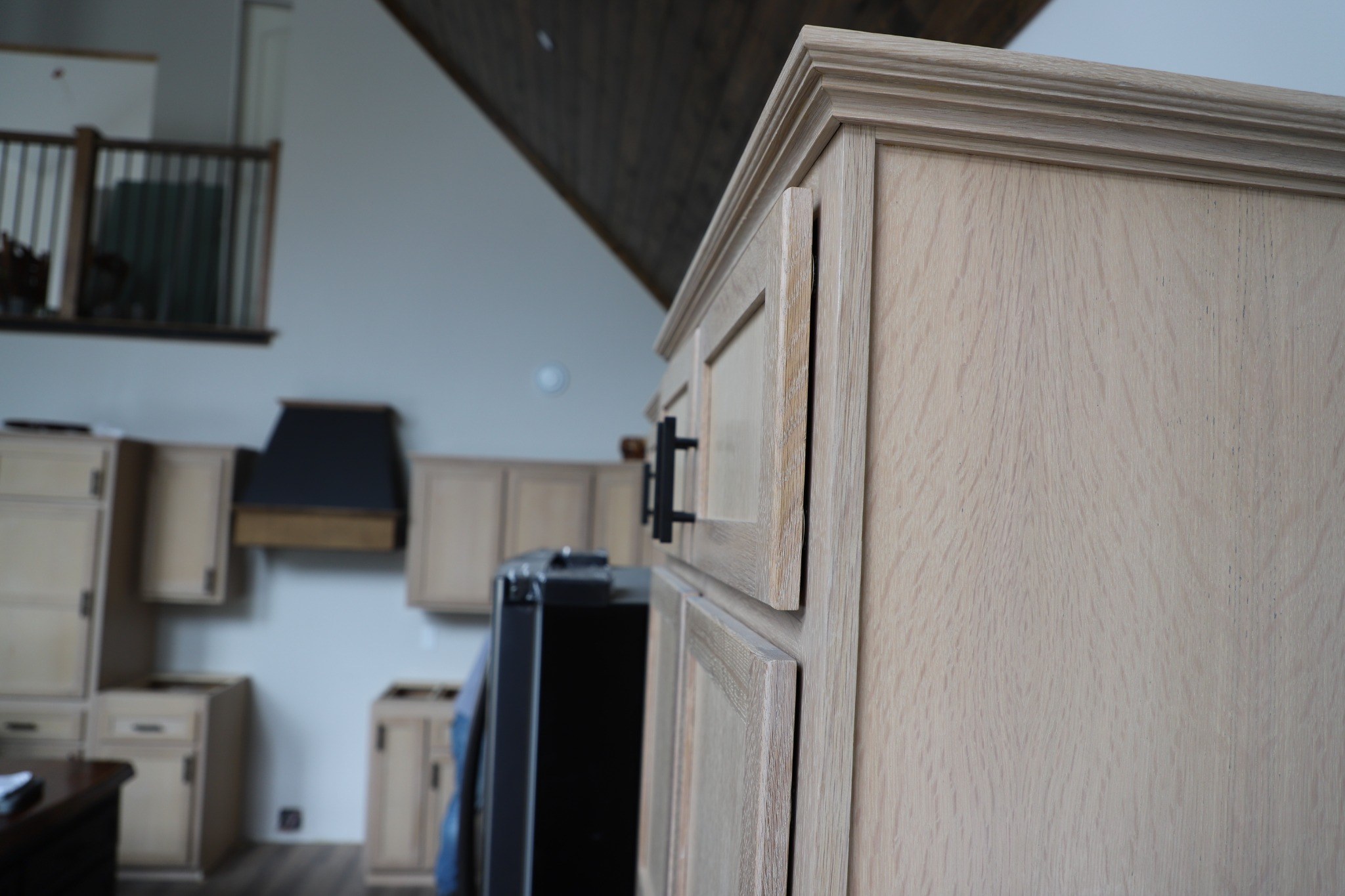 Close view of the finished side panel and crown molding on a natural wood upper cabinet.