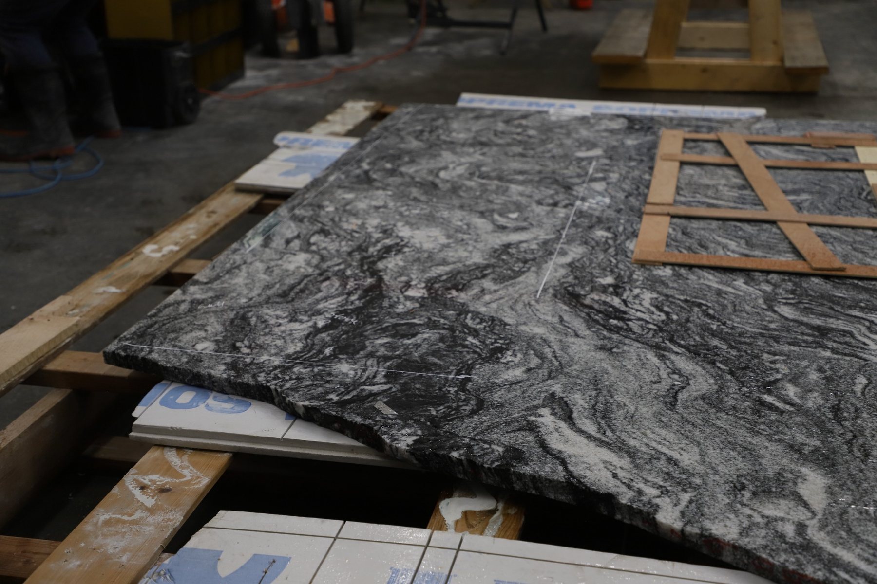 Full stone slab marked with countertop layout lines and physical templates.