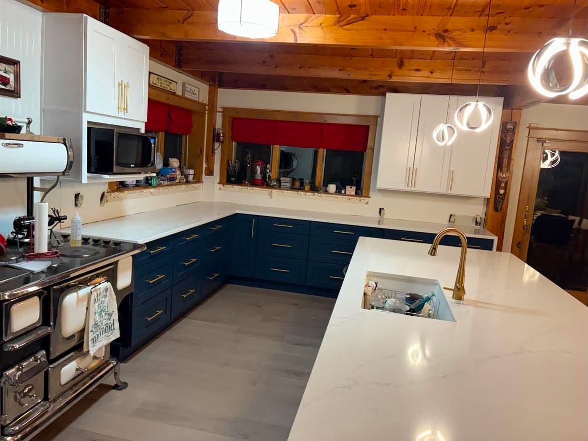 White stone island countertop detail, blue cabinetry.