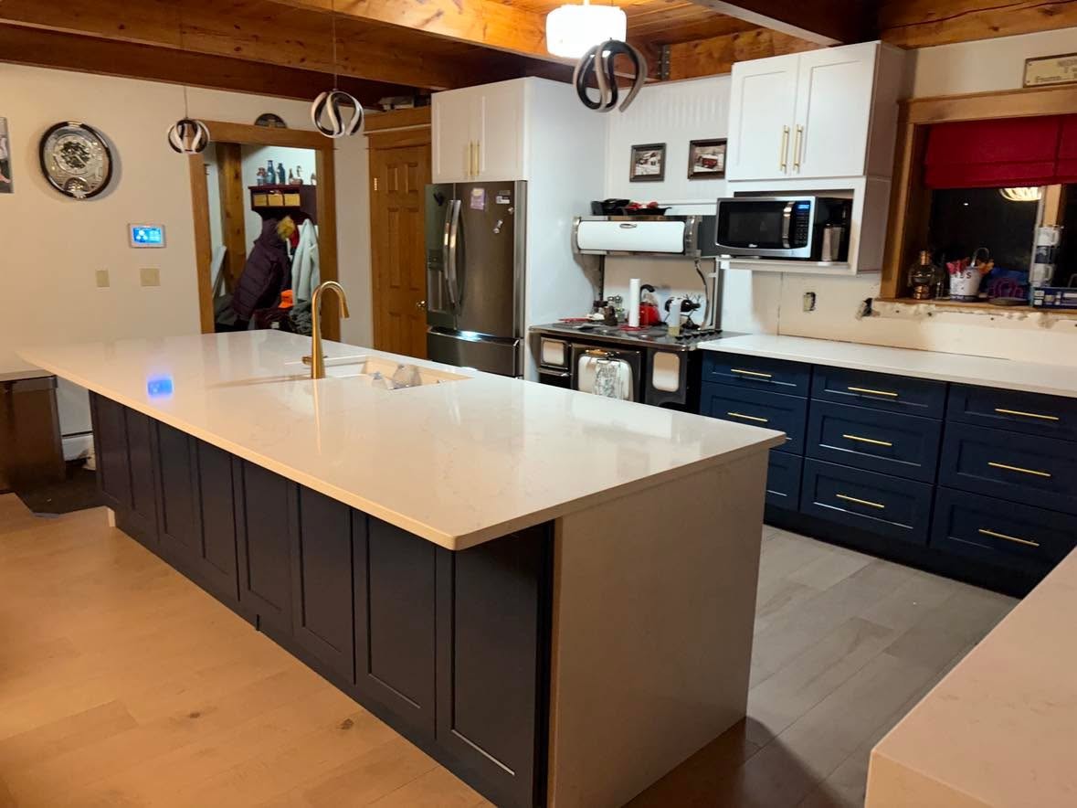 Perimeter countertop with undermount sink and white stone surface.