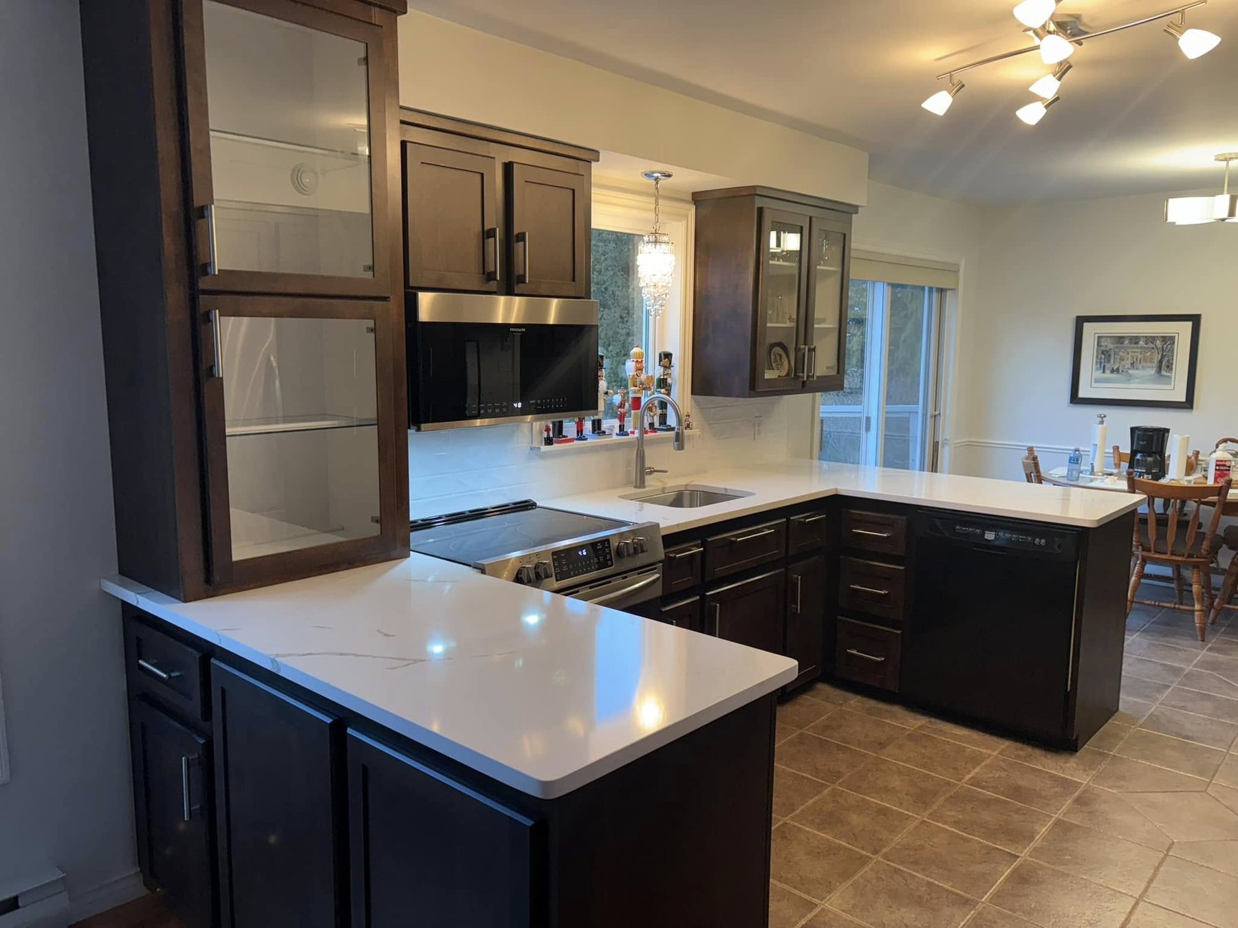 Dark cabinet kitchen with light countertop — secondary angle.