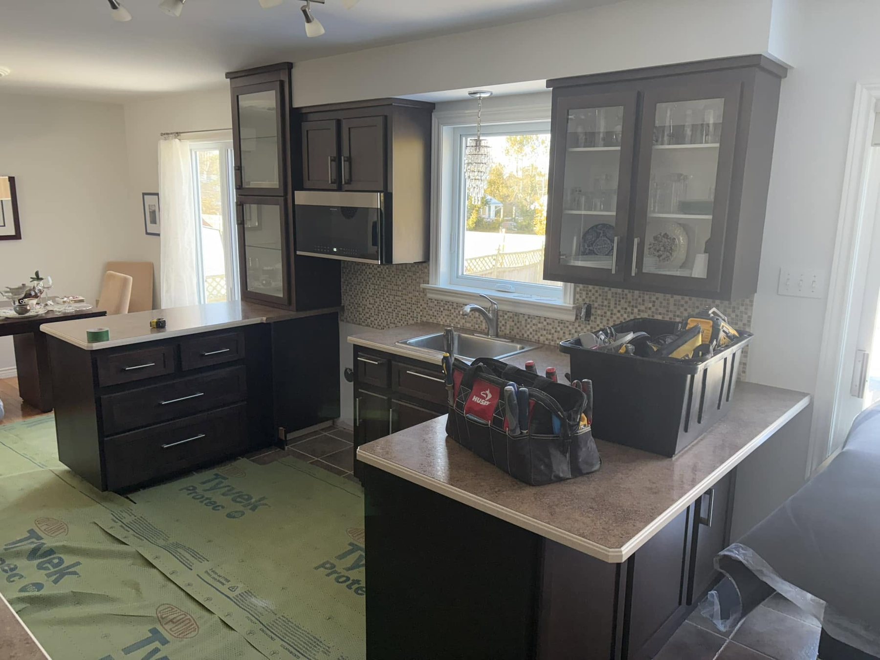 Dark cabinet kitchen — cabinetry and countertop installation in progress.