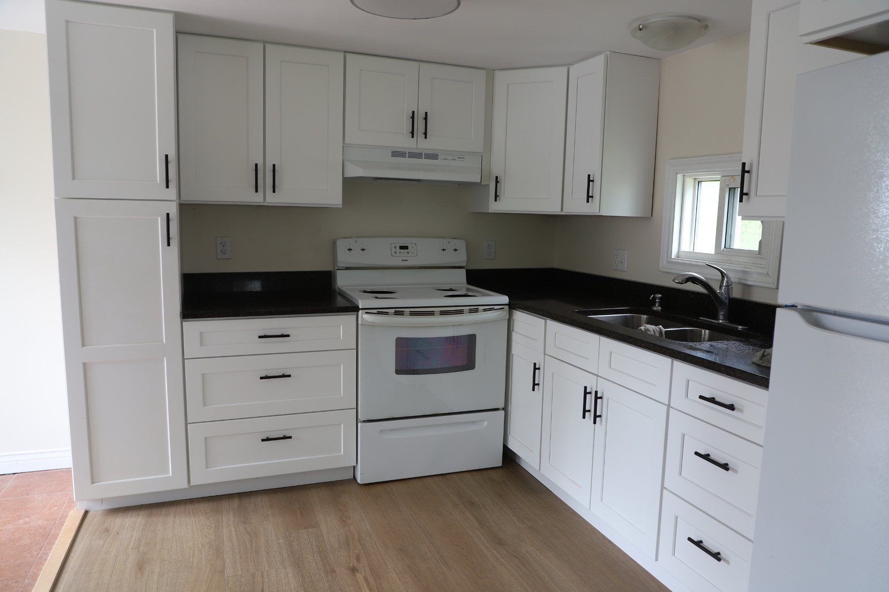 Dark Stone Kitchen with White Cabinetry — Oak Bay Rock & Tile